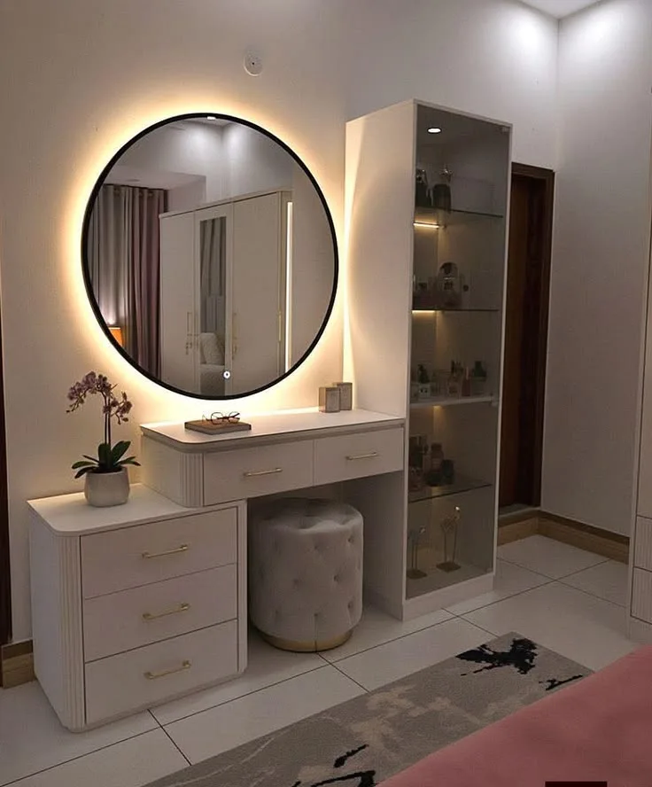 A round illuminated mirror and layered accent lighting